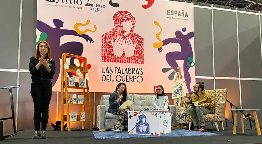 Tres personas en la tarima del salón B de Corferias durante el evento ‘Un horizonte que se expande: homenaje a 24 escritores con discapacidad de la literatura universal’.