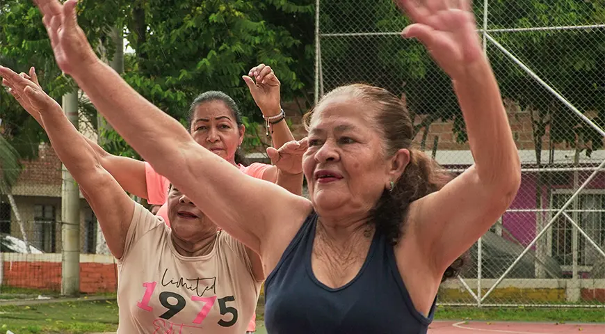 Mujeres del programa CuidArte, en Cali, hacen ejercicio en un parque local