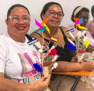 Mujeres de CuidArte en Boyacá muestran adornos y sonríen